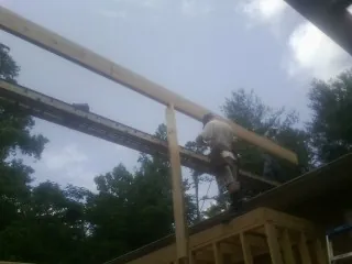 Carpenter setting a ridge beam over a new addition frame — Ice Dam Removal by Roofing Brothers in Minor Hill