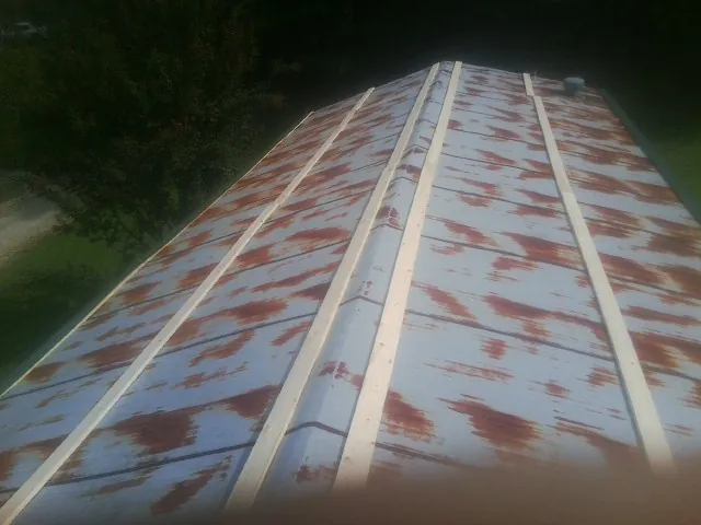 Rusted metal roof panels with new wood purlins before replacement — Storm Damage Roof Repair in Minor Hill by Roofing Brothers