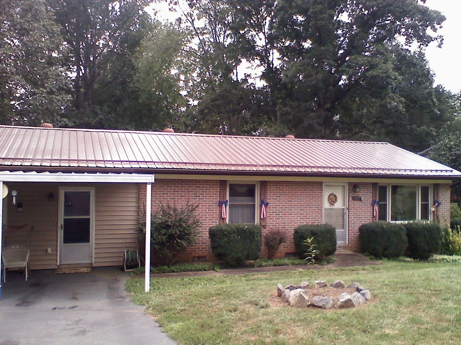Bronze metal roof and carport on a brick ranch home — Roof Repair work by our crew in Minor Hill